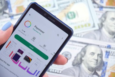Kharkiv, Ukrayna - 13 Mart 2023: Akıllı telefon ekranında Paeveryone mobil bankacılık uygulaması. Amerikan dolar banknotlarının arka planı.