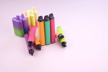 Pembe arka planda tek kullanımlık elektronik sigara seti. Modern sigara, buhar ve nikotin konsepti.