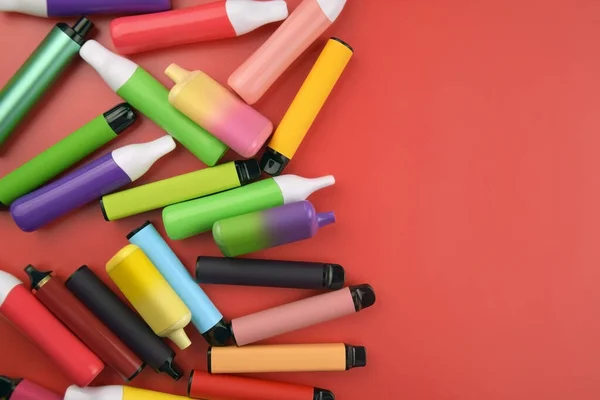 Set Cigarrillos Electrónicos Desechables Multicolores Sobre Fondo Rojo Concepto Tabaquismo —  Fotos de Stock