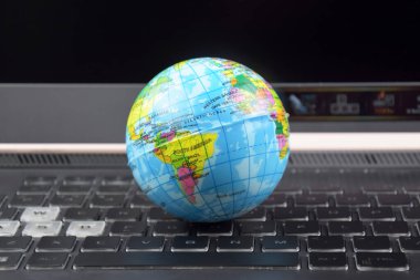 Üzerinde dünya küresi olan dizüstü bilgisayar klavyesi. İnternet 'te bilgi arama kavramı.