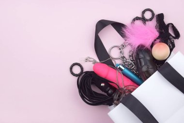 Seks oyuncakları beyaz bir pakette, arka planda bir seks dükkanına ait metin var. Cinsel sağlık kavramı.