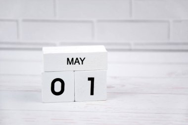 1 Mayıs 'ı gösteren beyaz ahşap takvim.