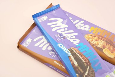 KHARKIV, UKRAINE - 12 Şubat 2023: Oreo aromalı çikolatalı Milka ve yumuşak pembe arkaplanda karamel.