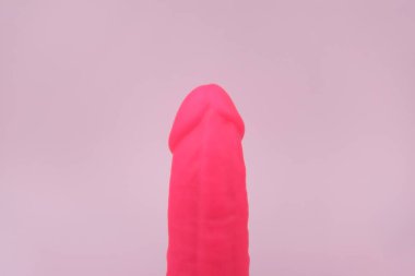 Pembe arka planda pembe vibratör ve seks dükkanı için metin. Cinsel sağlık kavramı.