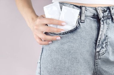 Kot pantolonun cebinde prezervatif. Enfeksiyonu önlemek için. Dünya AIDS Günü. Cinsel sağlık kavramı.