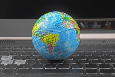 Üzerinde dünya küresi olan dizüstü bilgisayar klavyesi. İnternet 'te bilgi arama kavramı.