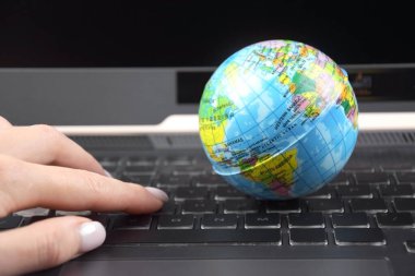 Üzerinde dünya küresi olan dizüstü bilgisayar klavyesi. İnternet 'te bilgi arama kavramı.