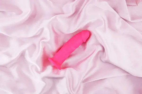 stock image Pink vibrator on pink fabric with copy text for sex shop. Sexual health concept.