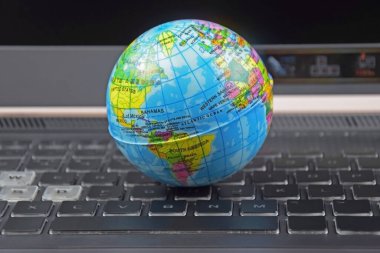 Üzerinde dünya küresi olan dizüstü bilgisayar klavyesi. İnternet 'te bilgi arama kavramı.