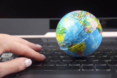 Üzerinde dünya küresi olan dizüstü bilgisayar klavyesi. İnternet 'te bilgi arama kavramı.