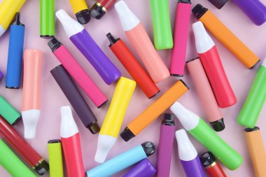 Pembe arka planda tek kullanımlık elektronik sigara seti. Modern sigara, buhar ve nikotin konsepti.