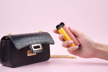 Pembe arka planda tek kullanımlık elektronik sigara seti. Modern sigara, buhar ve nikotin konsepti.