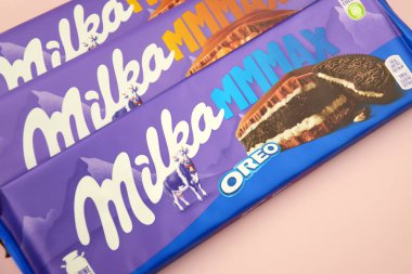 KHARKIV, UKRAINE - 12 Şubat 2023: Oreo aromalı çikolatalı Milka ve yumuşak pembe arkaplanda karamel.