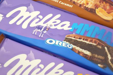 KHARKIV, UKRAINE - 12 Şubat 2023: Oreo aromalı çikolatalı Milka ve yumuşak pembe arkaplanda karamel.