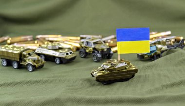 Amerikan dolarlarının arka planında Ukrayna bayrağı olan bir savaş tankı. Askeri yardım kavramı.