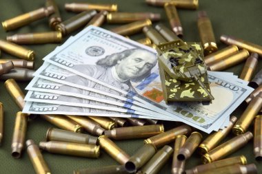 Dolarların arka planında mermi kovanları olan oyuncak savaş tankı. Savaş ve finans kavramı.