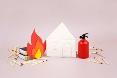 Oyuncak kırmızı yangın söndürücünün yanına bir kutu kibrit konmuş. Yangın güvenliği kavramı. Uluslararası İtfaiyeciler Günü.