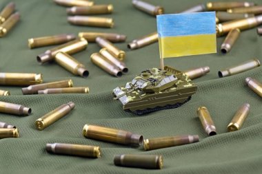 Amerikan dolarlarının arka planında Ukrayna bayrağı olan bir savaş tankı. Askeri yardım kavramı.