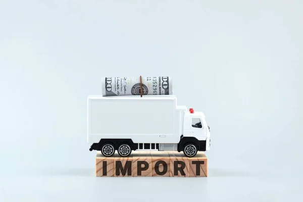 White toy truck on blocks with the text IMPORT. Logistics and wholesale trade concept.