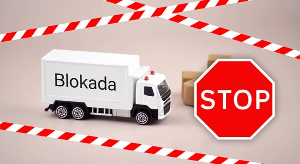 White toy cargo truck or van and signage of prohibition to pass Poland customs border. The concept of border blockade between Poland and Ukraine