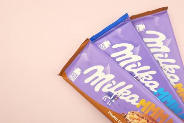 KHARKIV, UKRAINE - 12 Şubat 2023: Oreo aromalı çikolatalı Milka ve yumuşak pembe arkaplanda karamel.