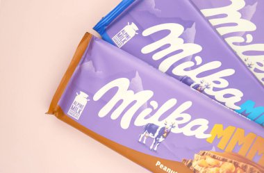 KHARKIV, UKRAINE - 12 Şubat 2023: Oreo aromalı çikolatalı Milka ve yumuşak pembe arkaplanda karamel.