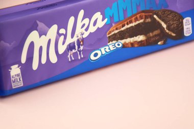 KHARKIV, UKRAINE - 12 Şubat 2023: Oreo aromalı çikolatalı Milka ve yumuşak pembe arkaplanda karamel.