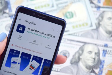Kharkiv, Ukrayna - 13 Mart 2023: İskoçya Kraliyet Bankası mobil bankacılık uygulaması akıllı telefon ekranında. Amerikan dolar banknotlarının arka planı.