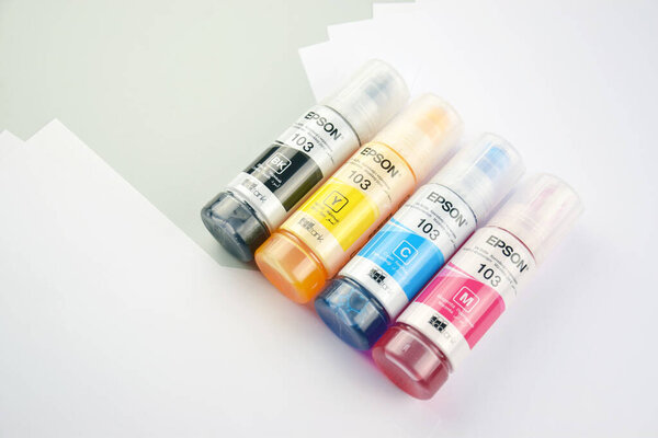 Харьков, Украина - 11 февраля 2023 года: Четыре бутылки чернил Epson, желтый, красный, синий, черный, встроенный в принтер серии Epson L3150.