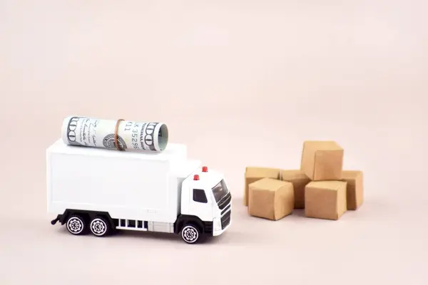 White toy truck with boxes on a light background, space for text. Logistics and wholesale trade concept.