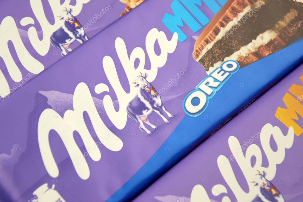 KHARKIV, UKRAINE - FEBRUARY 12, 2023: Chocolate brand Milka with Oreo flavor and caramel on a soft pink background.