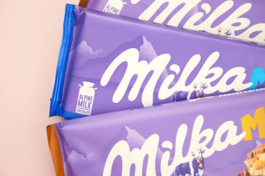 KHARKIV, UKRAINE - 12 Şubat 2023: Oreo aromalı çikolatalı Milka ve yumuşak pembe arkaplanda karamel.