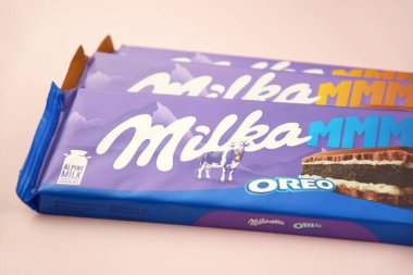 KHARKIV, UKRAINE - 12 Şubat 2023: Oreo aromalı çikolatalı Milka ve yumuşak pembe arkaplanda karamel.