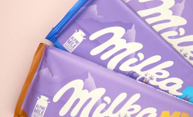 KHARKIV, UKRAINE - 12 Şubat 2023: Oreo aromalı çikolatalı Milka ve yumuşak pembe arkaplanda karamel.
