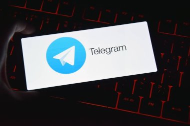 Kharkiv, Ukrayna, Temmuz 06, 2023: Klavyede kırmızı ışıklandırmalı akıllı telefon ekranında telgraf simgesi.