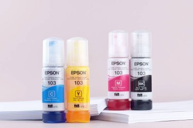 KHARKIV, UKRAINE - FEBRUARY 11, 2023: Four bottles of ink Epson, yellow, red, blue, black, built-in to the Epson L3150 series printer.