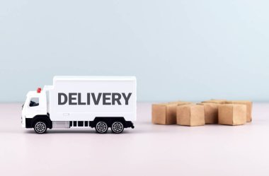 Bloklarda beyaz oyuncak kamyonu ve DELIVERY yazıları. Lojistik ve toptan ticaret kavramı.