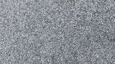 Gri ezilmiş taş yığınının dokusu. Farklı şekil ve boyutlardaki birçok taşın arkaplan resmi.
