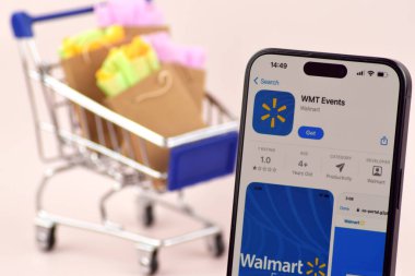 KHARKOV, UKRAINE - 18 Ağustos 2024: Akıllı telefonlu alışveriş arabası ekranda Walmart uygulaması açık.