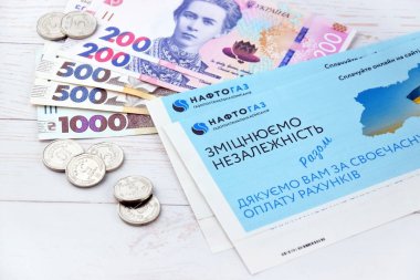 KHARKIV, UKRAINE - 2 Mart 2024: Ukrayna hryvnias para ile Naftogaz hizmet makbuzu.