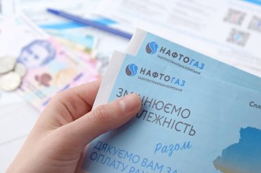 KHARKIV, UKRAINE - 2 Mart 2024: Ukrayna hryvnias para ile Naftogaz hizmet makbuzu.