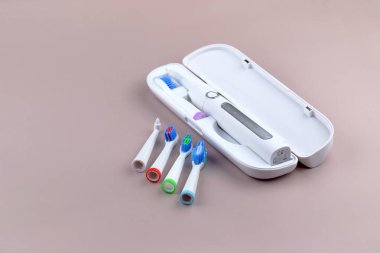 Gri yüzeyinde şarj edilebilir bataryası olan modern elektrikli ultrasonik diş fırçası. Diş bakımı.