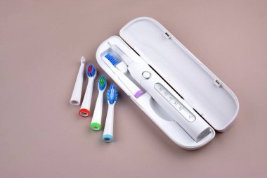 Gri yüzeyinde şarj edilebilir bataryası olan modern elektrikli ultrasonik diş fırçası. Diş bakımı.