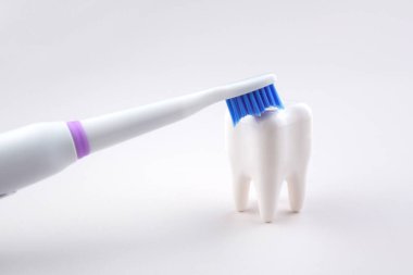 Gri yüzeyinde şarj edilebilir bataryası olan modern elektrikli ultrasonik diş fırçası. Diş bakımı.