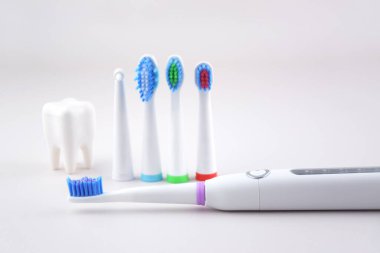 Gri yüzeyinde şarj edilebilir bataryası olan modern elektrikli ultrasonik diş fırçası. Diş bakımı.