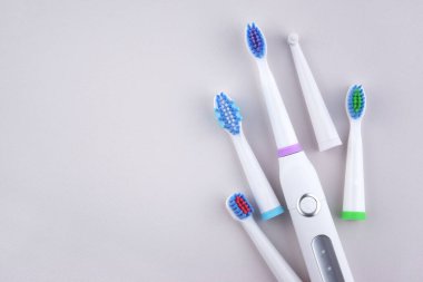 Gri yüzeyinde şarj edilebilir bataryası olan modern elektrikli ultrasonik diş fırçası. Diş bakımı.