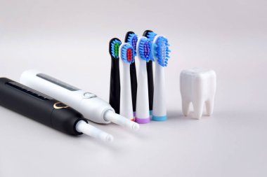Gri yüzeyinde şarj edilebilir bataryası olan modern elektrikli ultrasonik diş fırçası. Diş bakımı.