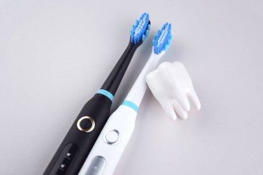 Gri yüzeyinde şarj edilebilir bataryası olan modern elektrikli ultrasonik diş fırçası. Diş bakımı.