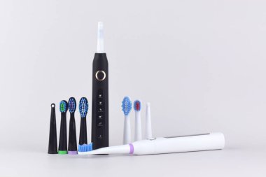 Gri yüzeyinde şarj edilebilir bataryası olan modern elektrikli ultrasonik diş fırçası. Diş bakımı.