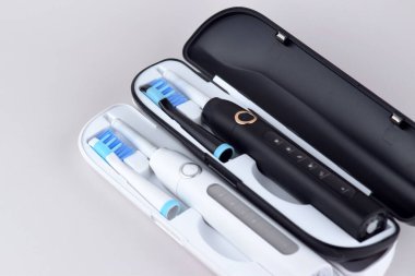 Gri yüzeyinde şarj edilebilir bataryası olan modern elektrikli ultrasonik diş fırçası. Diş bakımı.